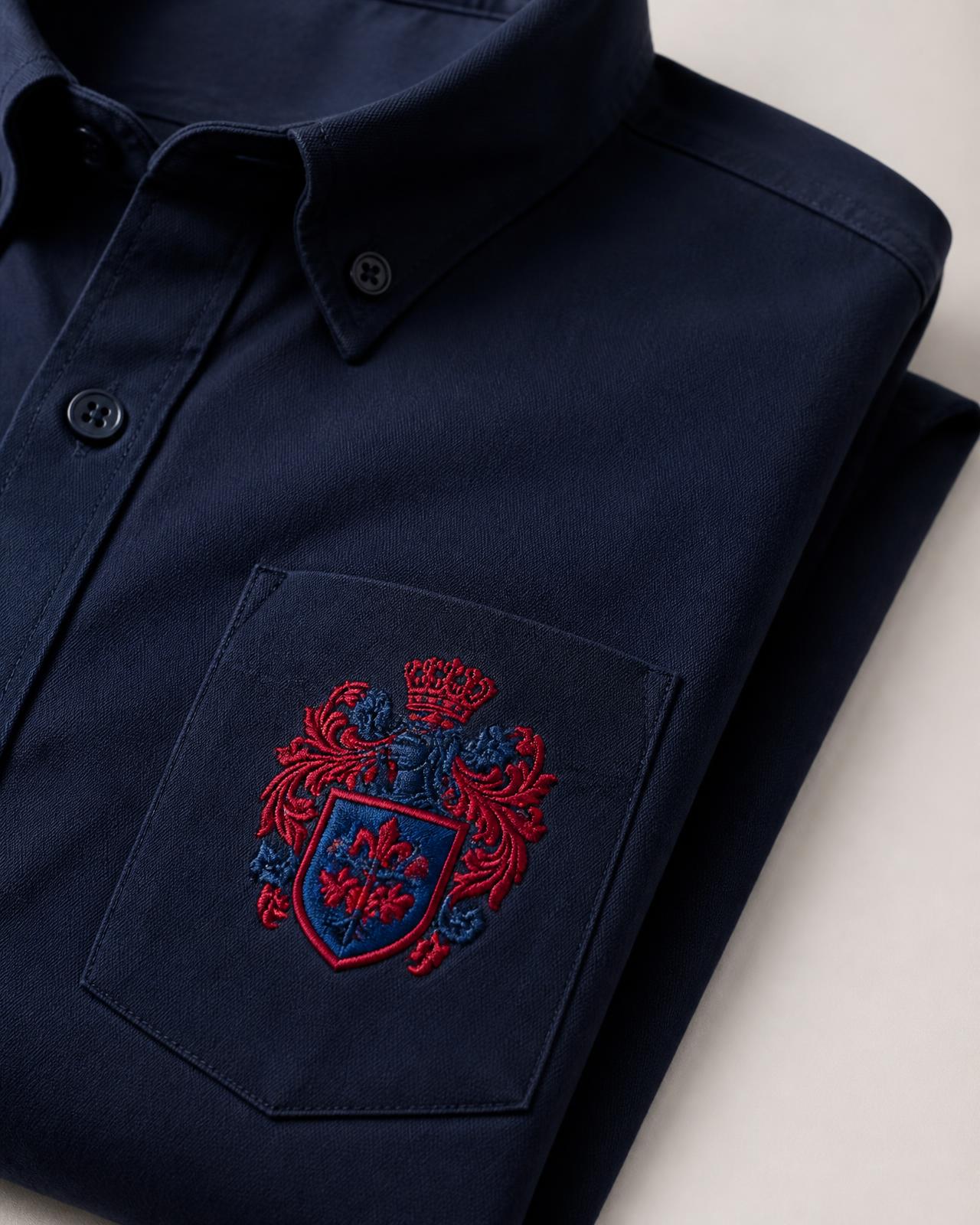 Navy shirt with a detailed red and blue embroidered crest stitched on the chest pocket